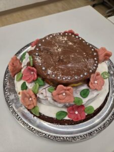 Geburtstagstorte mit Schokoladenglasur und Marzipanrosen auf Silberplatte