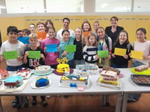 Schülerinnen und Schüler der 4a-Klasse der NMS St. Peter am Kammersberg präsentieren ihre Tortenkreationen.